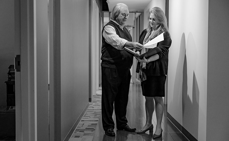 Attorneys Ronald Hilley And Mia Frieder Working Together In Office Hallway