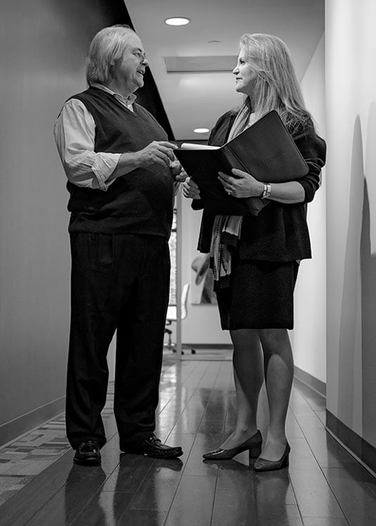 Attorneys Ronald Hilley And Mia Frieder Working Together In Office Hallway